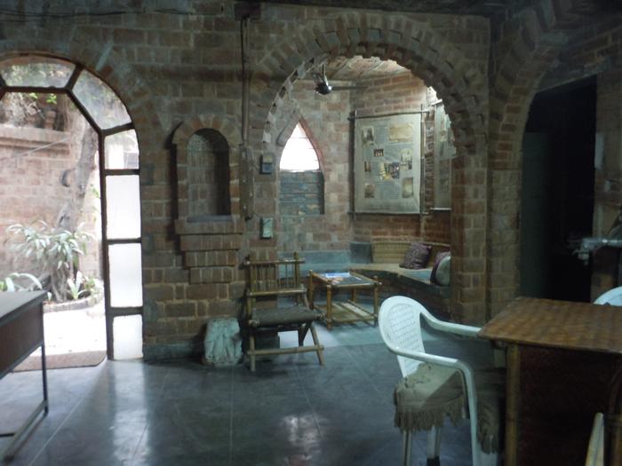 The interior room showing the supporting brick arches framing the entrance and the sitting area 