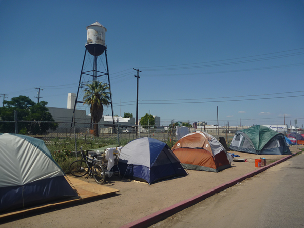 A Homeless Encampment situated in Fresno, California, USA. As in many US cities, such encampments are criminalized in the downtown core, but concentrated and tolerated in the industrialized outskirts. Photo by Christopher Herring.