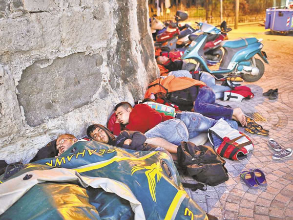 FLEEING EN MASSE: Migrants from Syria sleep along the walls of a 14th-century fortress in Kos, Greece. (WIN MCNAMEE/GETTY IMAGES/WALL STREET JOURNAL AUG. 2015 FRONT PAGE).
